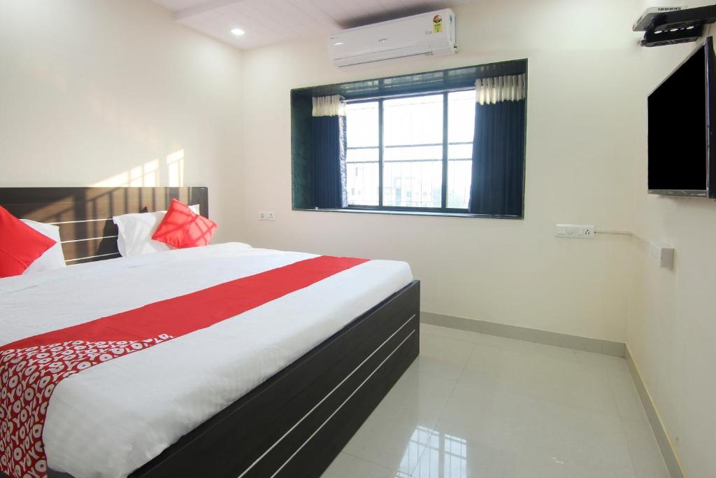 1 dormitorio con cama, ventana y TV en OYO Villa 31 en Akot