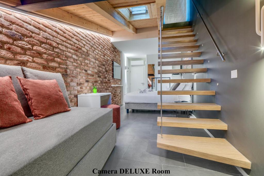 Zimmer mit Ziegelwand und Treppe in der Unterkunft Forum Suites in Verona