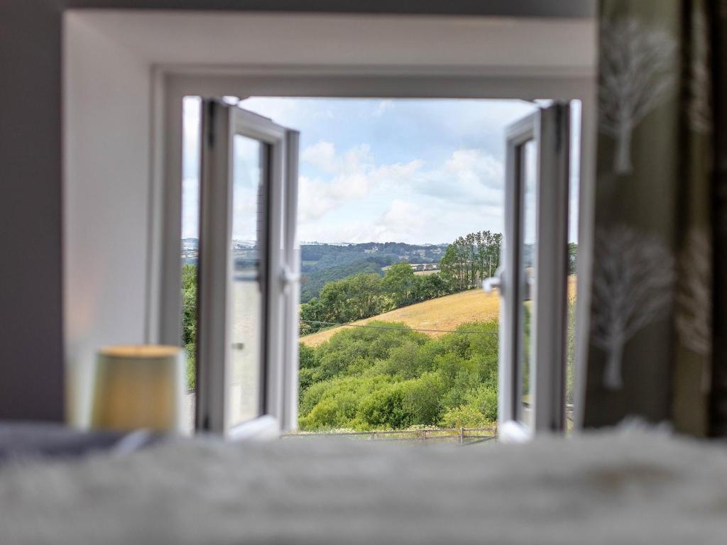 an open window with a view of a field at 3 Bed in South Molton 78304 in Kings Nympton