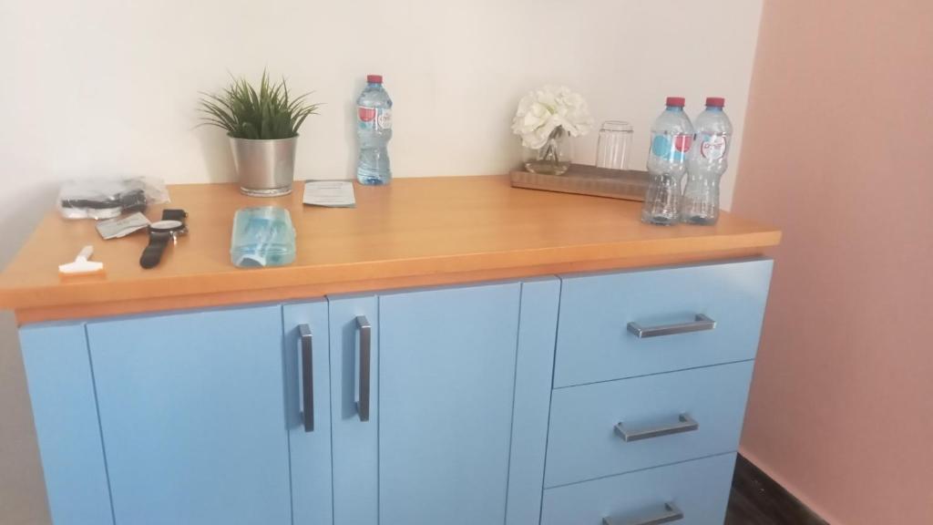 a desk with blue cabinets and bottles on top at Conjunto villas del portal dos in Soledad