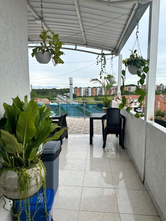 a patio with a table and chairs and plants at Edificio Pacifica Aptos in Cali