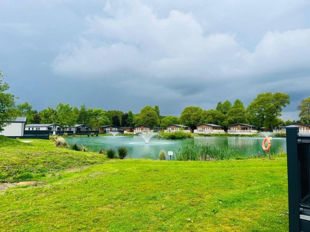 a view of a lake with houses in the background at Waterside Retreat With Hot Tub in Pocklington