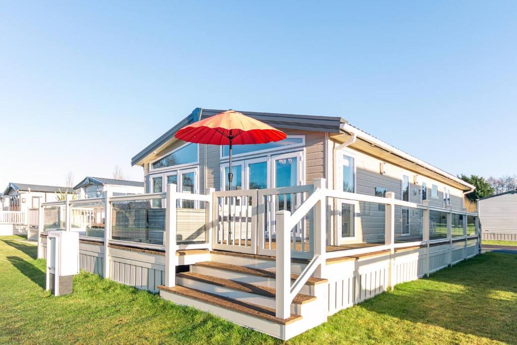 a house with a deck with an umbrella on it at Lakeside Gem with Hot Tub in York