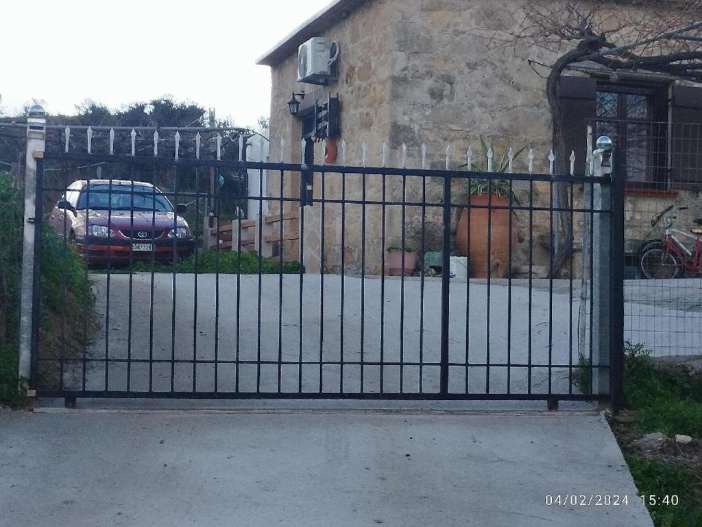 a black metal gate in front of a house at TRADITIONAL HOUSE MARIA in Azoyirás