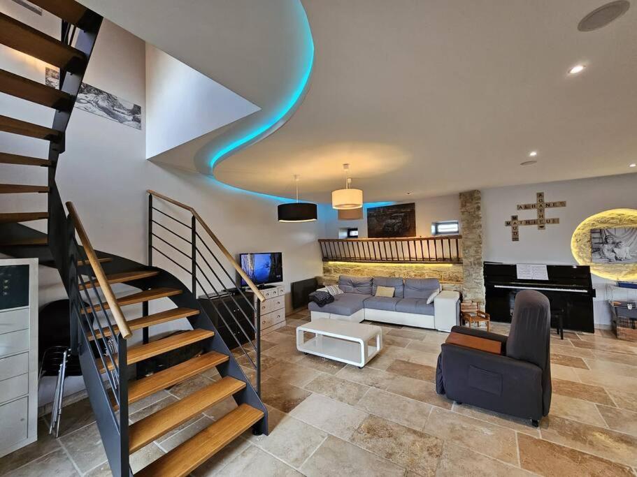 - un salon avec un escalier en colimaçon dans une maison dans l'établissement Maison familiale au cœur du D-Day, à Vaux-sur-Aure