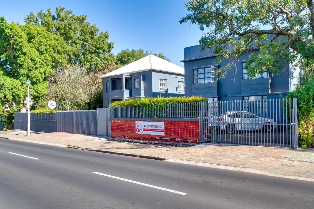 a blue house with a fence next to a street at Life & Leisure Communal-Living in Stellenbosch