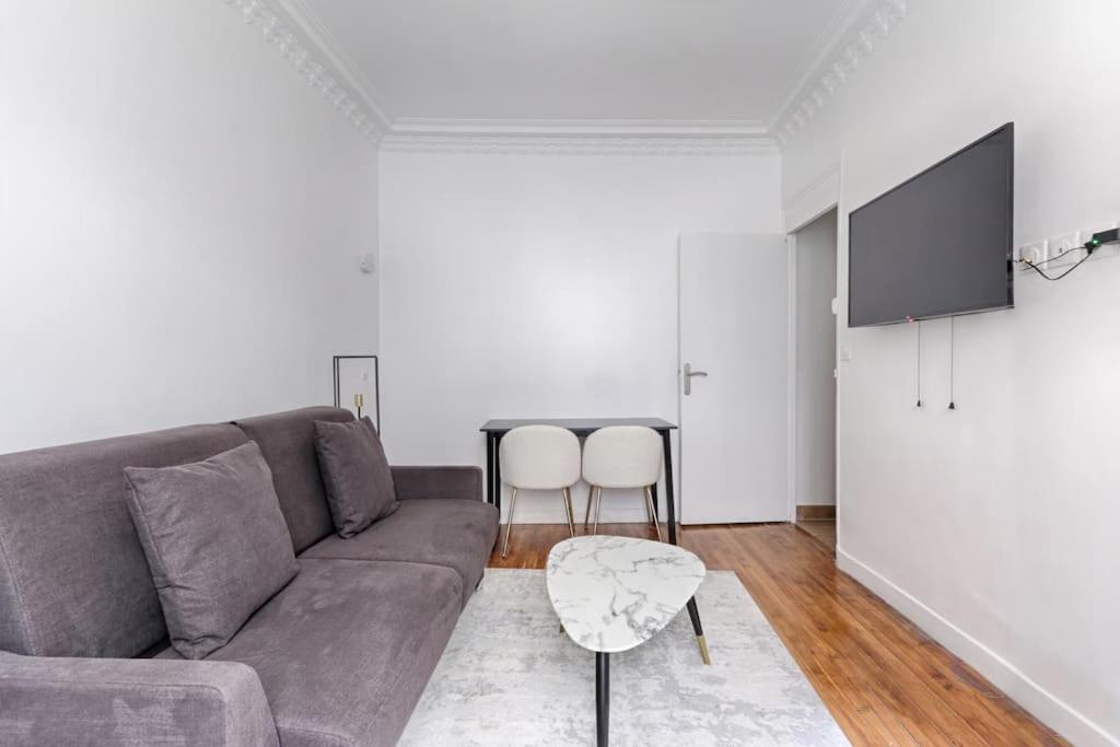 un salon avec un canapé et une télévision à écran plat dans l'établissement Montmartre/Natier : Cosy Studio 2P, à Paris