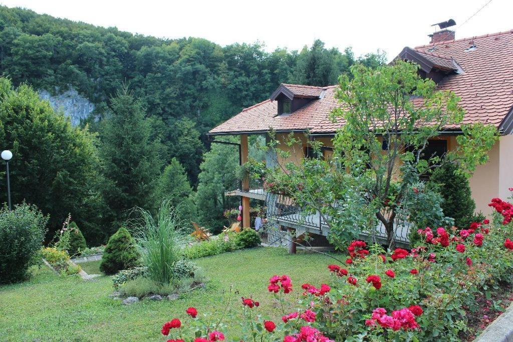 een huis met een tuin met bloemen in de tuin bij Holiday Home Jakovci in Netretić