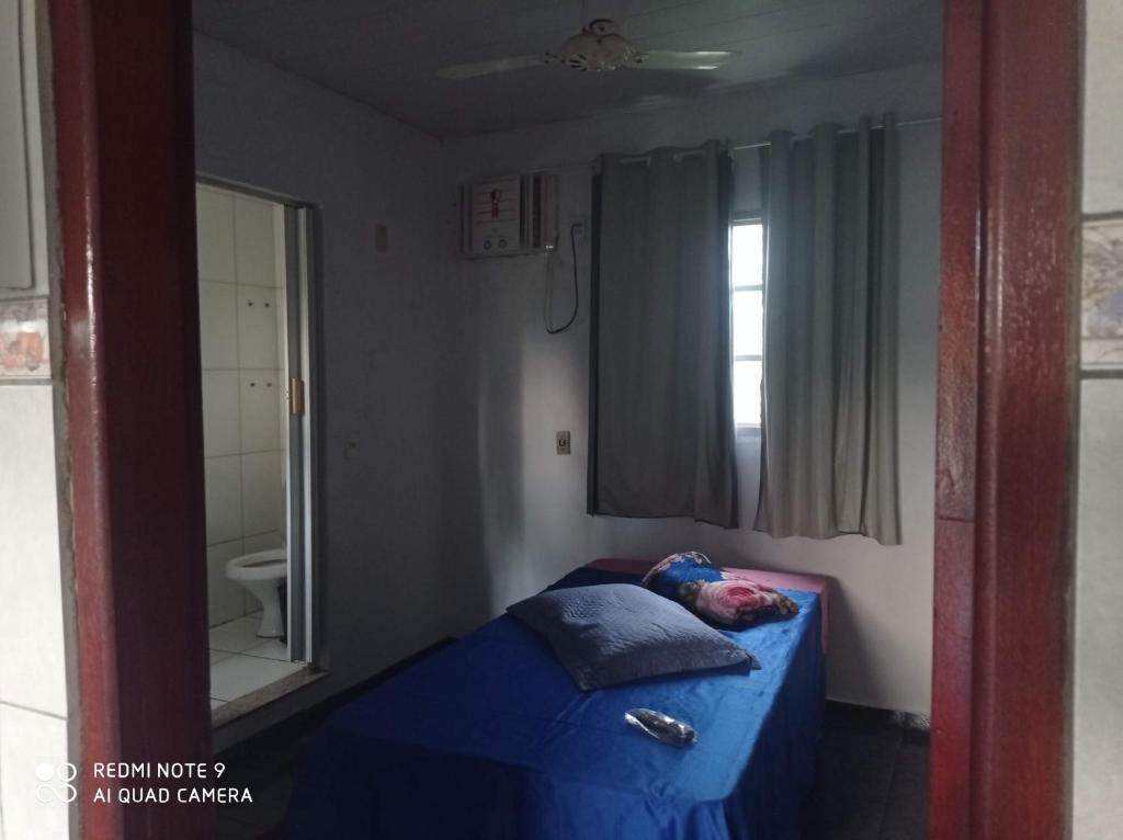 a bedroom with a blue bed with a mirror at Apartamento Aconchegante in Rondonópolis