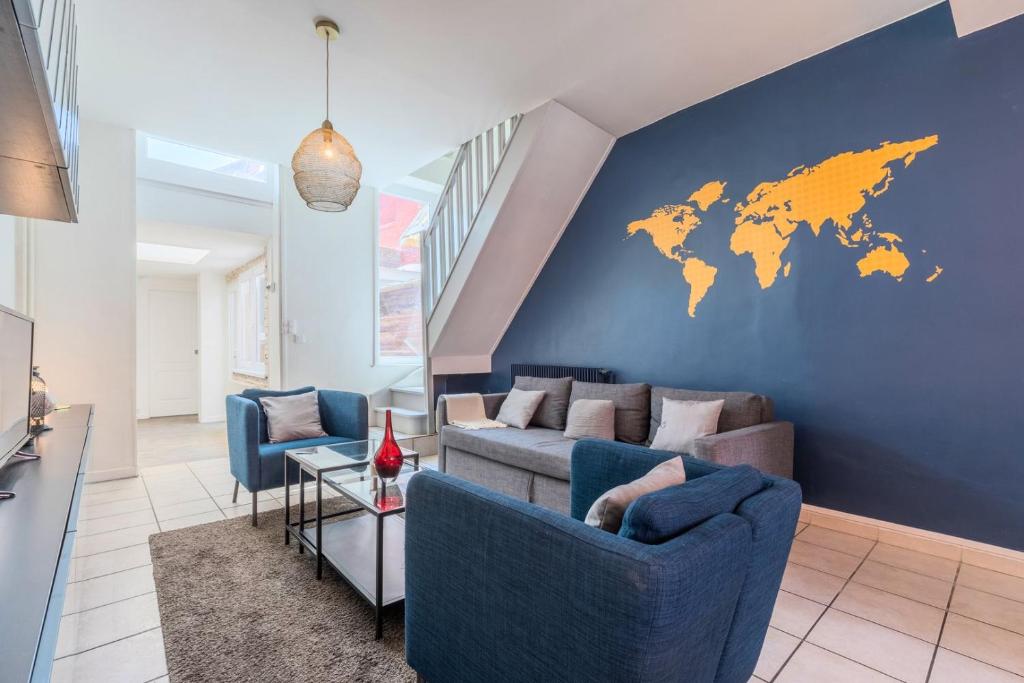 - un salon avec un canapé et une carte du monde sur le mur dans l'établissement 4 BR & 4 bathroom house close to Parc Barbieux, à Roubaix