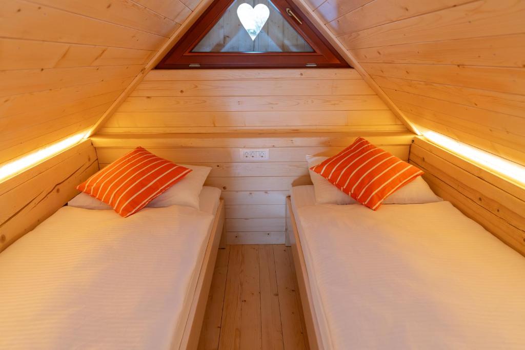 two beds in a small room with a window at Apartment Orehar in Bohinj