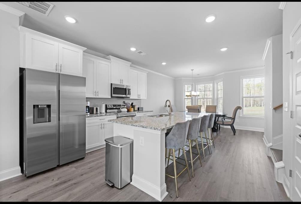a kitchen with white cabinets and a stainless steel refrigerator at The Arches in Lawrenceville
