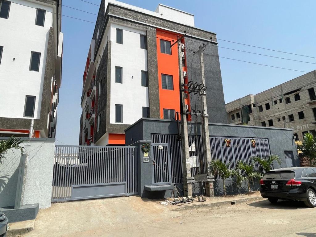 an orange and white building with a car parked in front at Sambest Homes in Lagos