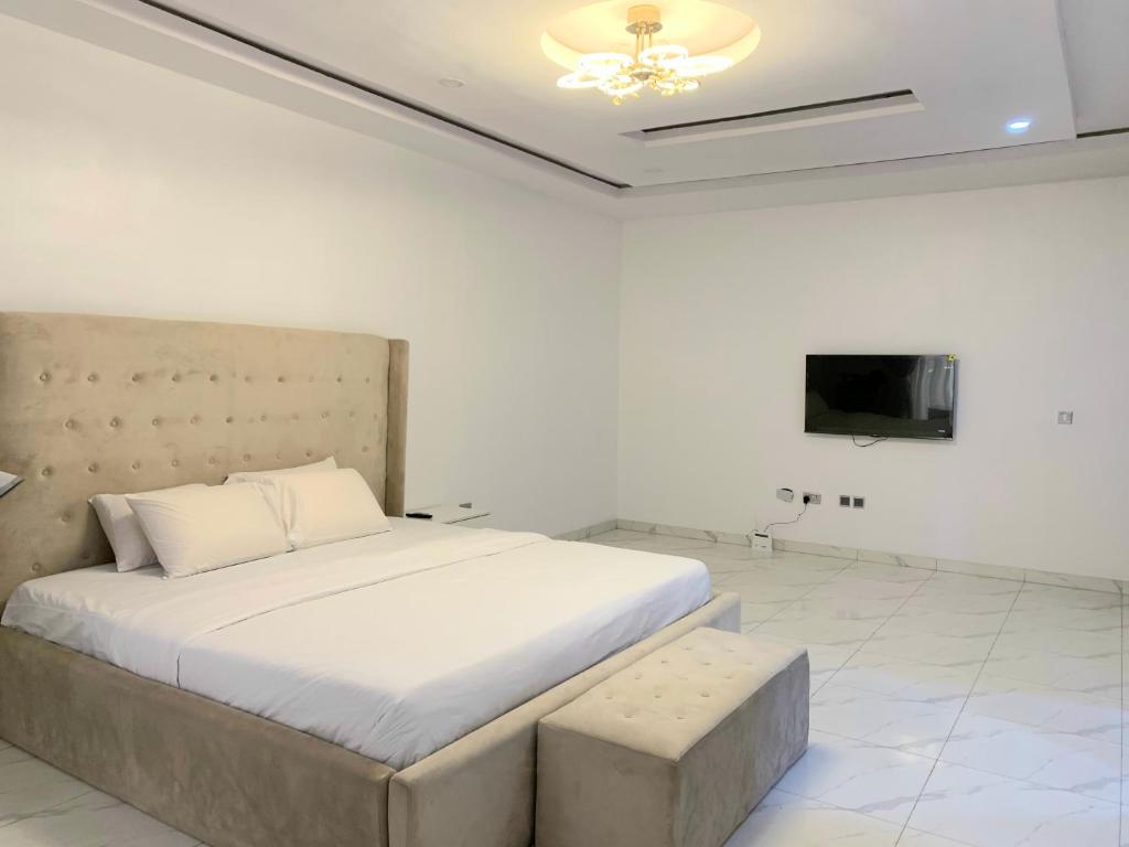 a bedroom with a large bed and a tv at The Residenze Adeniyi Jone Ikeja in Lagos