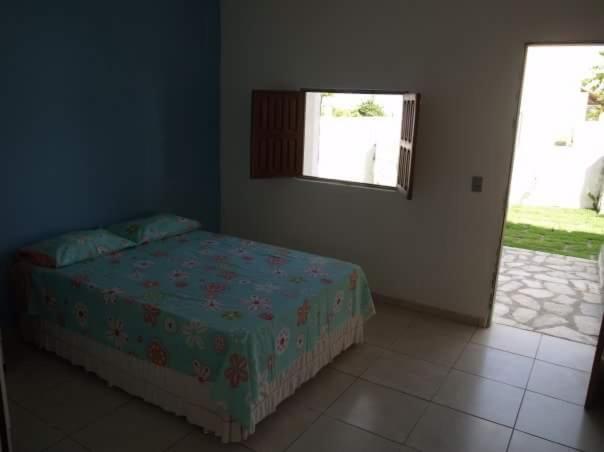 1 dormitorio con cama y ventana en Vila Harmonia en Conde