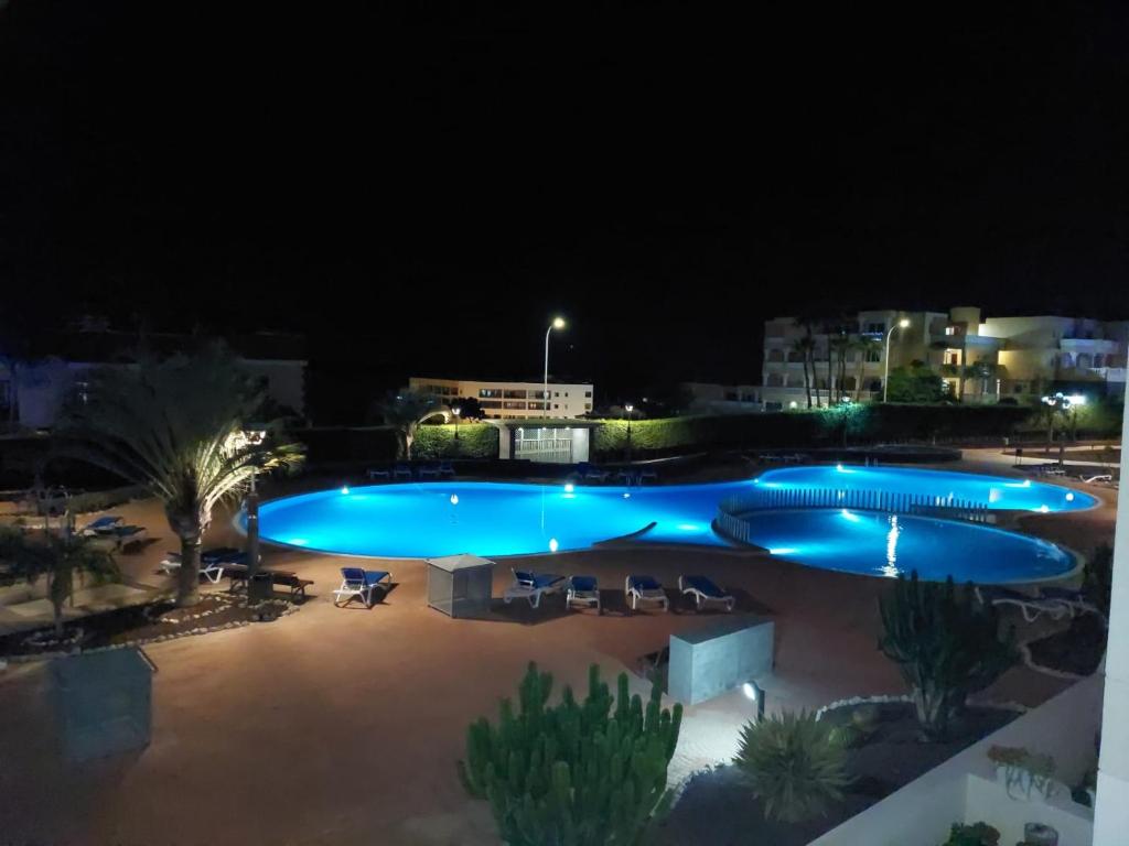 uma grande piscina à noite com luzes em Sunny Suite em San Miguel de Abona