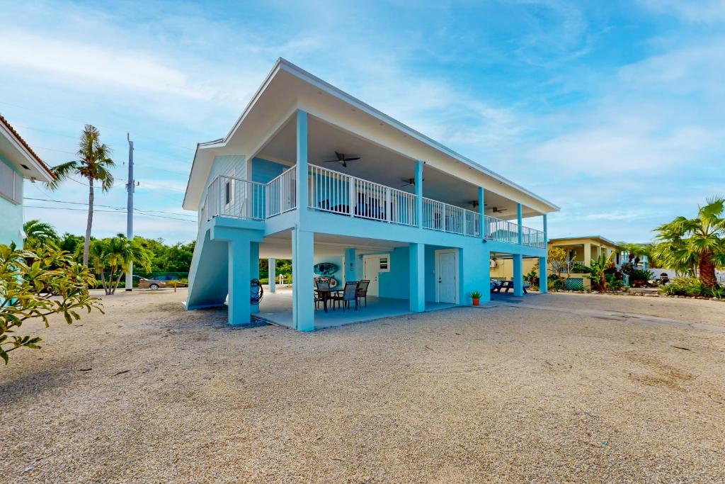 a blue house with a balcony on a beach at The Shimmering Swordfish in Marathon