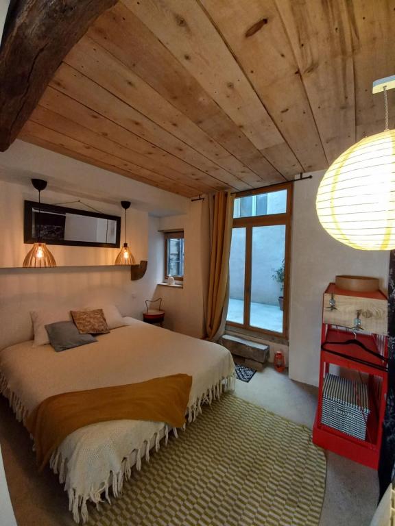 a bedroom with a large bed and a large window at Le patio in Oloron-Sainte-Marie