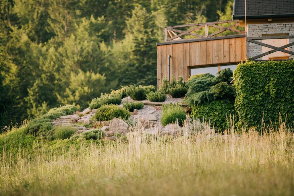 un giardino di fronte a un edificio in legno di Na Kupčku Estate "Nature Reatreat & Wellness" a Idrija