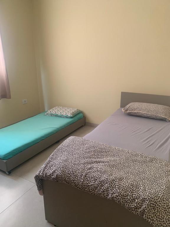 um quarto com duas camas num quarto em Linda Casa Próximo Aeroporto em Campo Grande