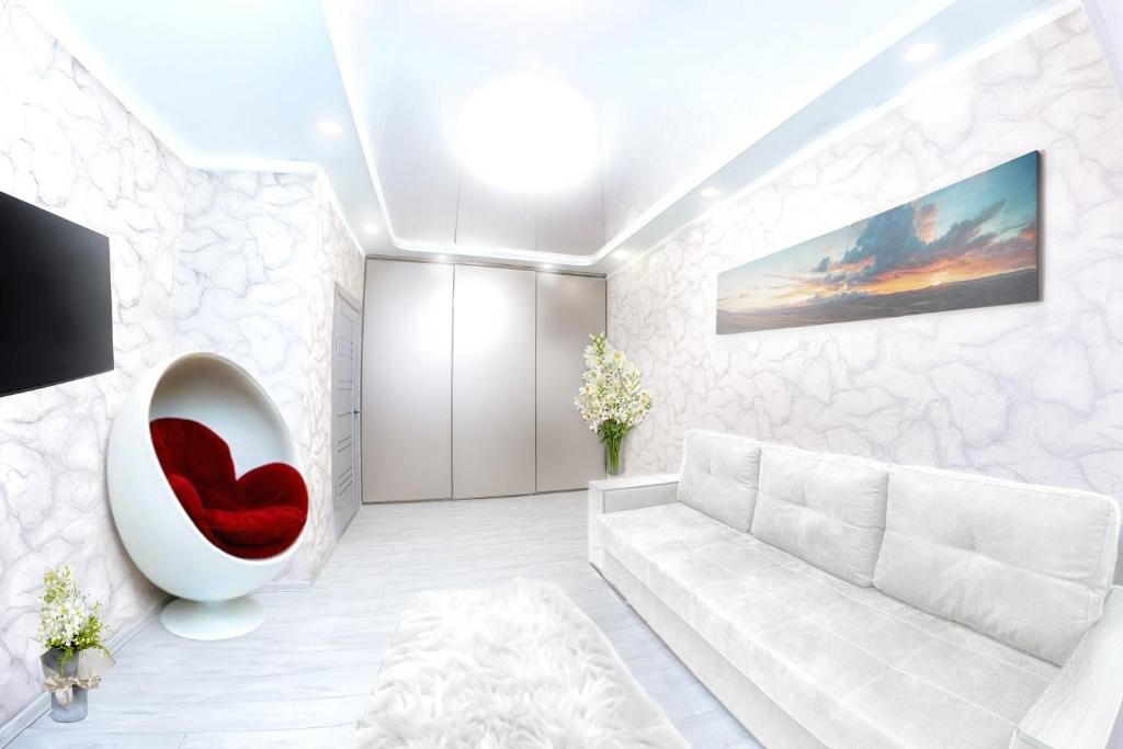 a living room with a white couch and a red chair at Европейская Пассаж ЦУМ in Dnipro