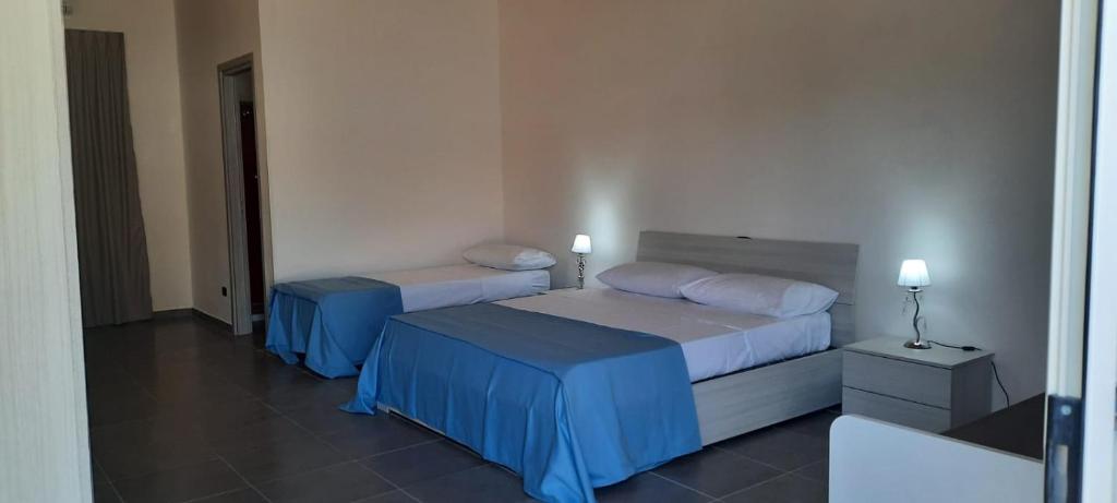 a hotel room with two beds and two lamps at Villaggio Jonio Blu in Bianco