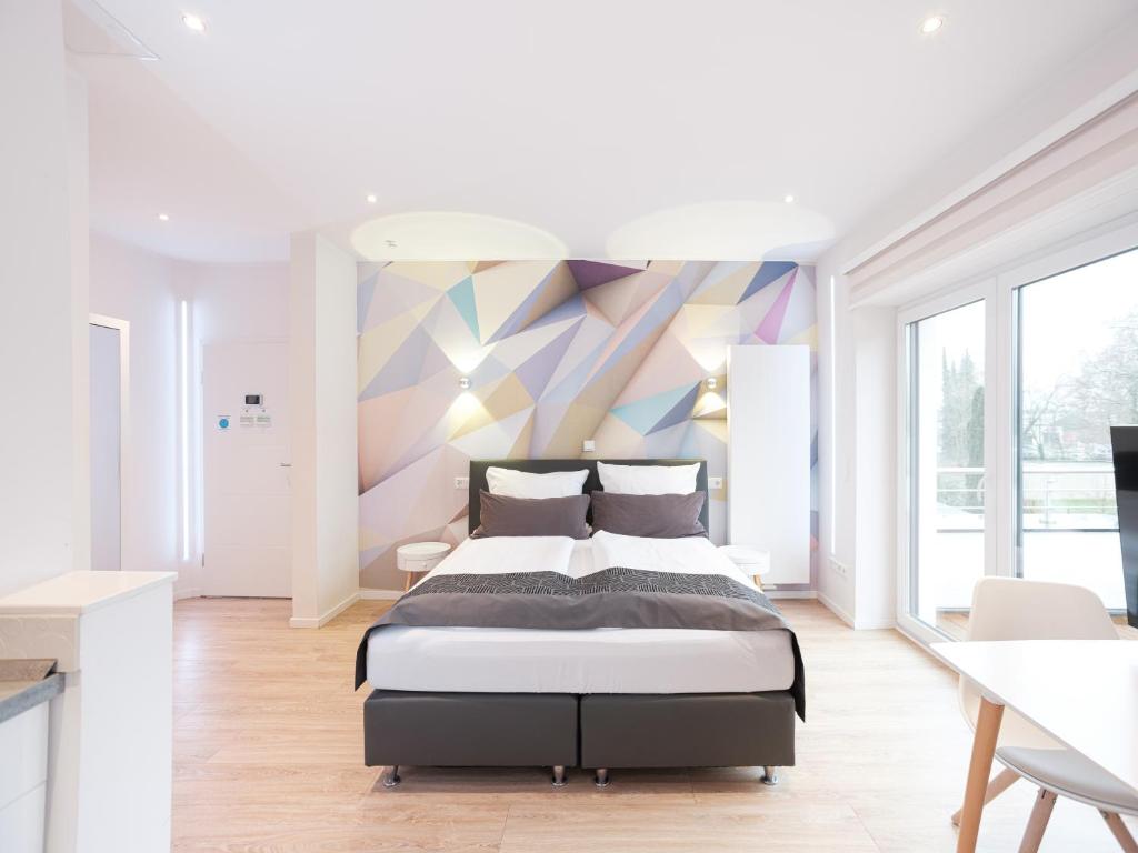 1 dormitorio con 1 cama y una pared colorida en business boarding lippstadt, en Lippstadt