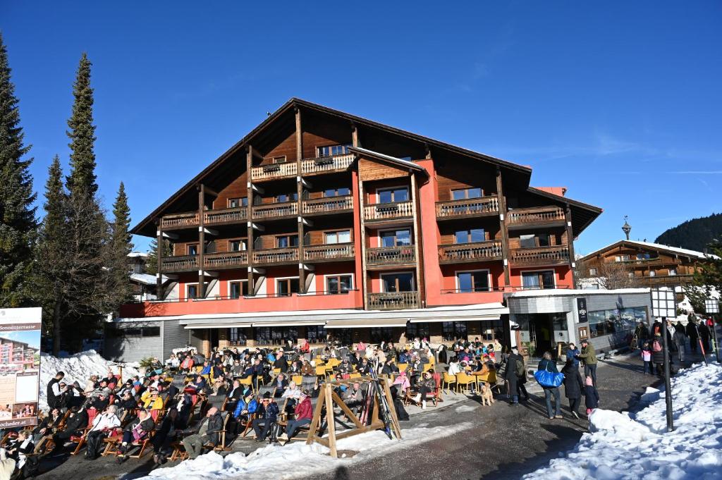 uma grande multidão de pessoas em frente a um alojamento de esqui em Hotel Hocheder em Seefeld no Tirol