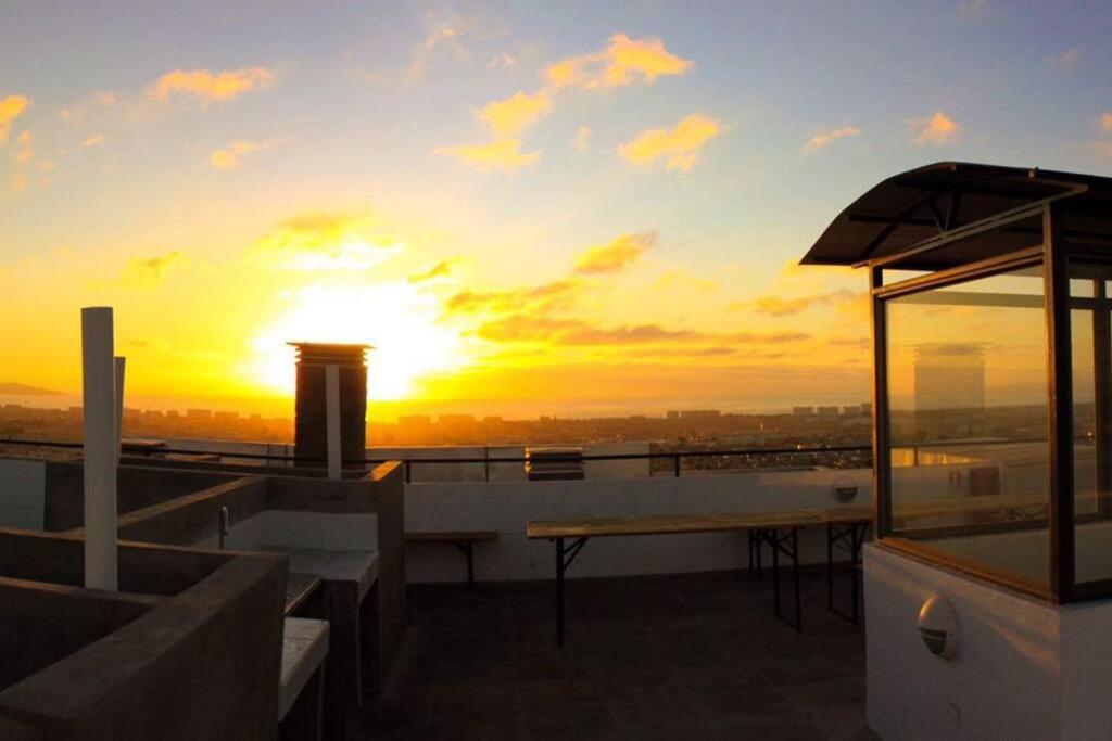 a sunset on the roof of a building with a table at Departamento Completo Terrazas San Joaquín La Serena in La Serena