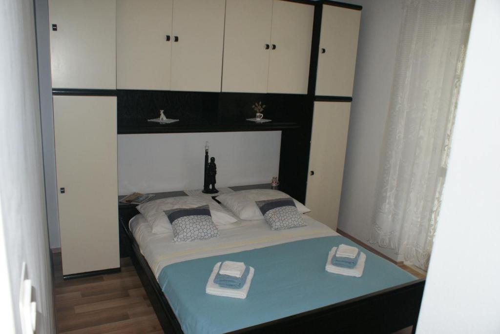 a bedroom with a bed with white cabinets at Korčula Guest House in Korčula