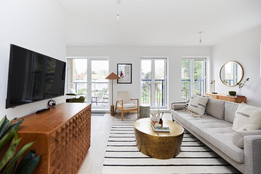 een woonkamer met een bank en een tv bij The Wembley Park Retreat - Modern 2BDR Flat with Balcony in Londen