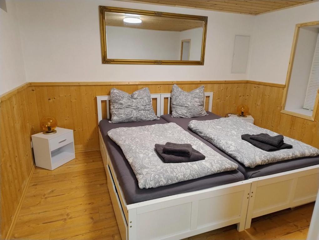 1 Schlafzimmer mit 2 Betten und einem Wandspiegel in der Unterkunft Ferienwohnung am Egelsee 