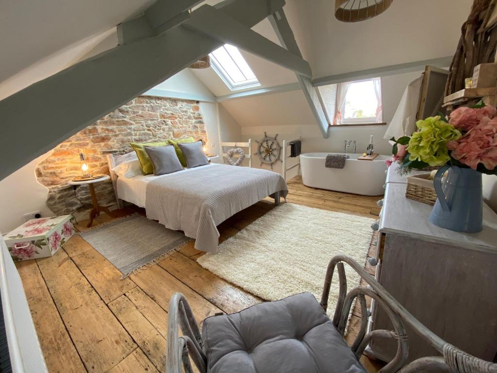 a attic bedroom with a bed and a bath tub at Cosy Fisherman’s Cottage: 150m to Brixham Harbour in Brixham