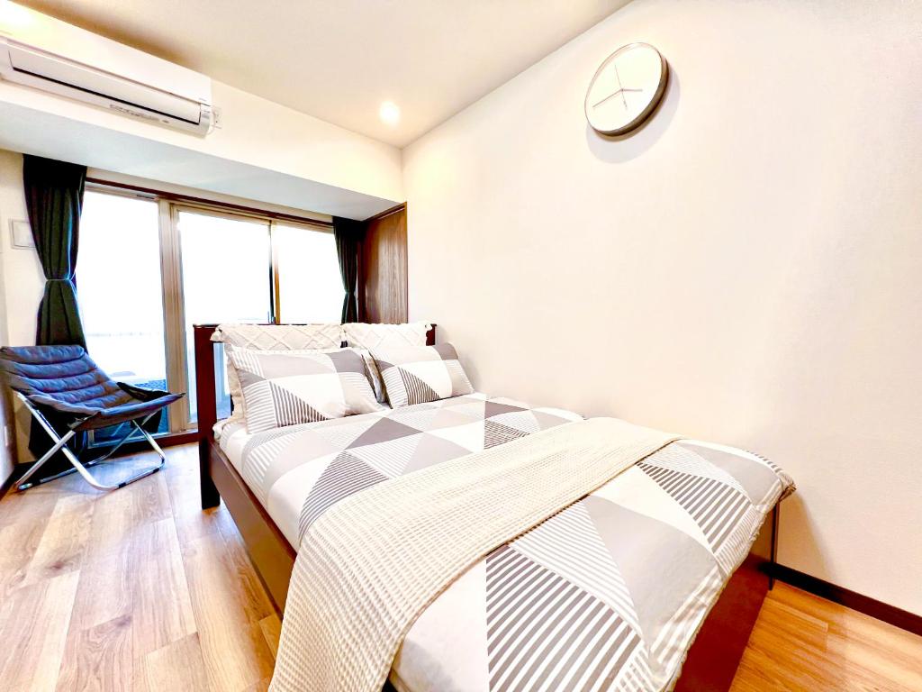 a bedroom with a bed and a clock on the wall at East Ikebukuro 2 Double Beds Apartment / Sunshine City in Tokyo