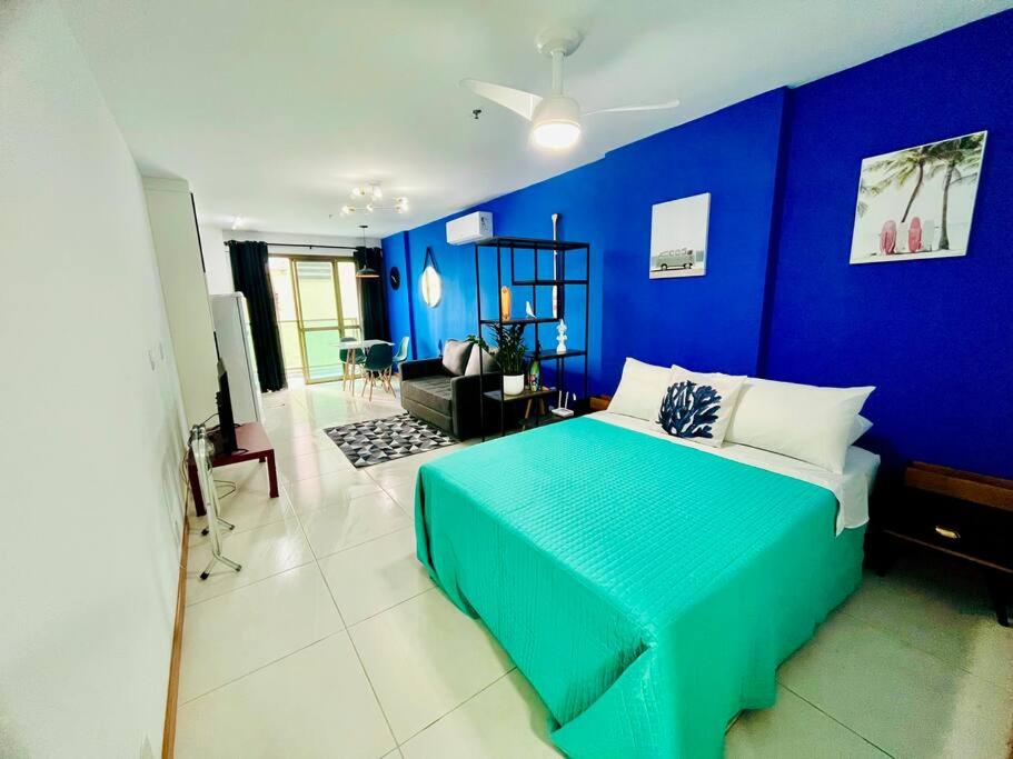 ein blaues Schlafzimmer mit einem Bett und einer blauen Wand in der Unterkunft Studio Acqua - estilo no melhor bairro da cidade in Niterói