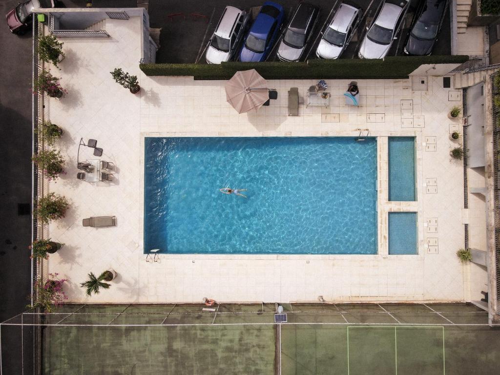an overhead view of a pool with a person swimming in it at Résidences Les Hauts de l'Indenié in Abidjan