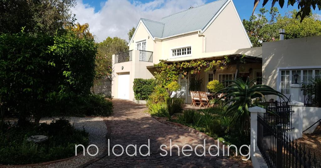 a white house with the words no load shedding at Jonquil Guest Cottage in Franschhoek