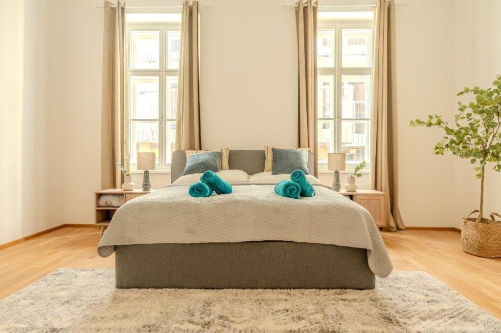 a bedroom with a large bed with two blue pillows at Deluxe Apartments near the center in Krems an der Donau