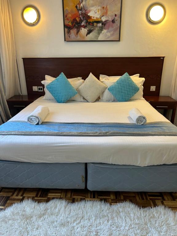 a bedroom with a large bed with blue and white pillows at Westland villa by Carol in Nairobi