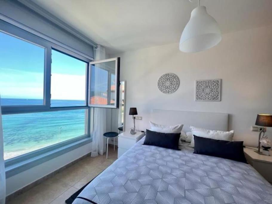 ein Schlafzimmer mit einem Bett und einem großen Fenster in der Unterkunft Öspede Sisarga Chica Malpica de Bergantiños-Costa da Morte in Malpica