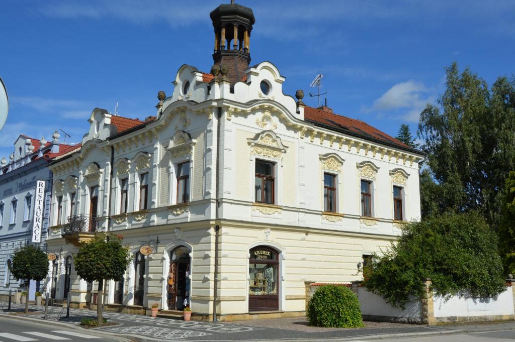 a white building with a tower on top of it at Penzion Věžička in Lázně Bělohrad