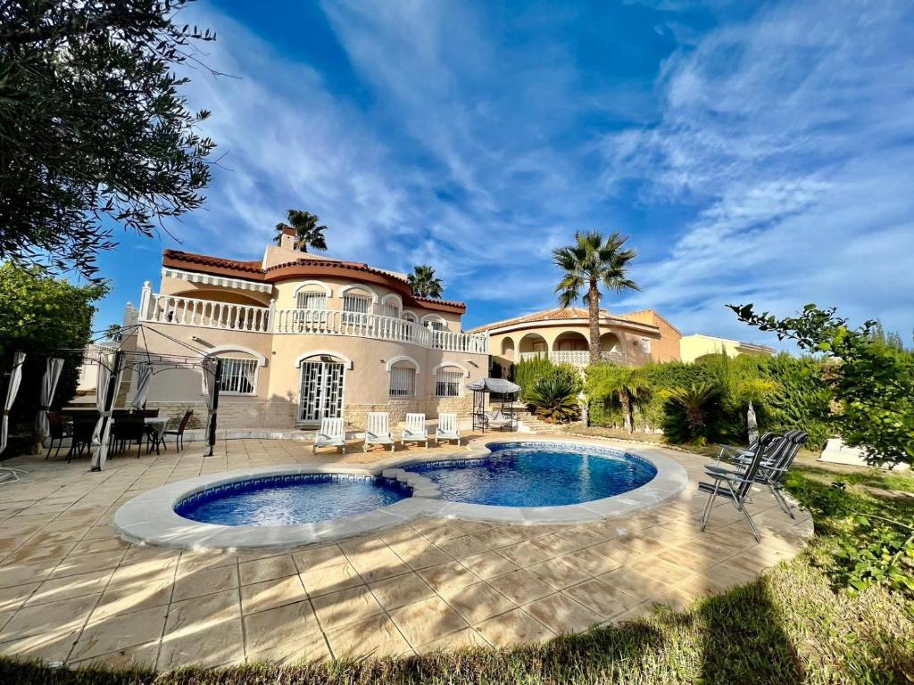 una casa con piscina frente a ella en Villa Calma en Ciudad Quesada