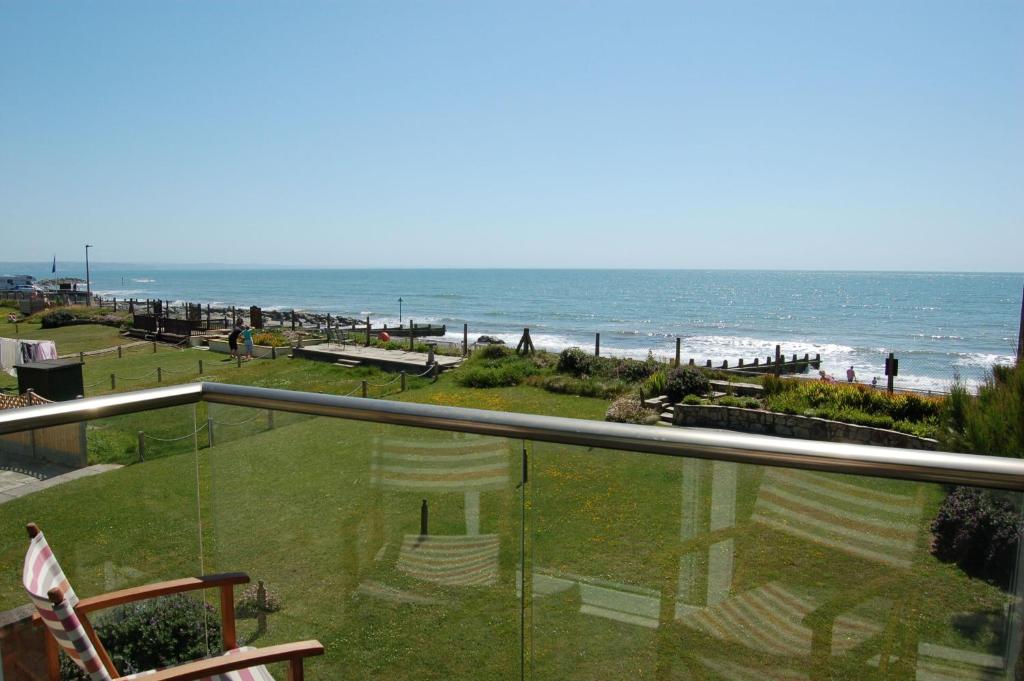 a balcony with a view of the beach and the ocean at Tywyn Beach House in Tywyn