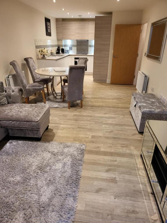 a living room with a table and chairs and a kitchen at Alderhouseplace in Maidenhead