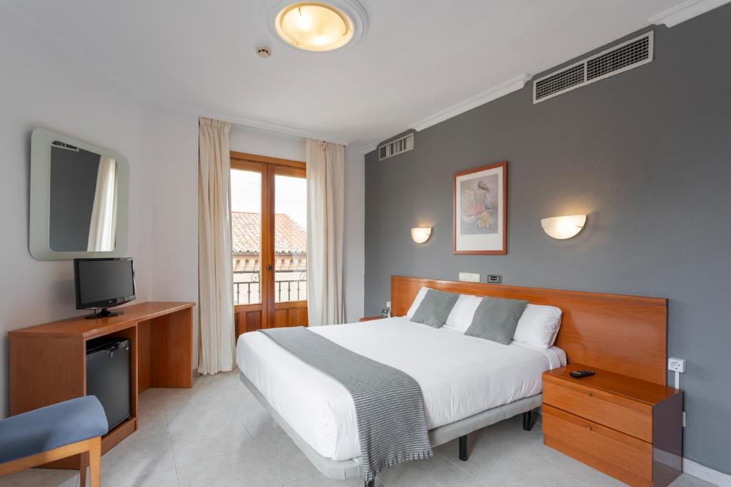um quarto com uma cama e uma televisão e uma cama sidx sidx em Hotel Alda Ciudad de Toro em Toro