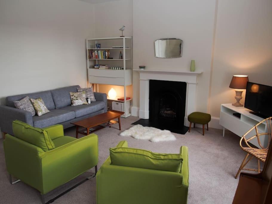 een woonkamer met een bank en stoelen en een open haard bij Stunning apartment in the centre of Corbridge in Corbridge