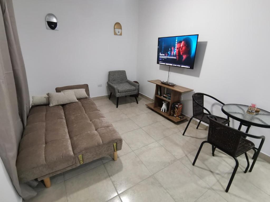 a living room with a couch and a table and a tv at Apartamento full en David, Chiriquí. 