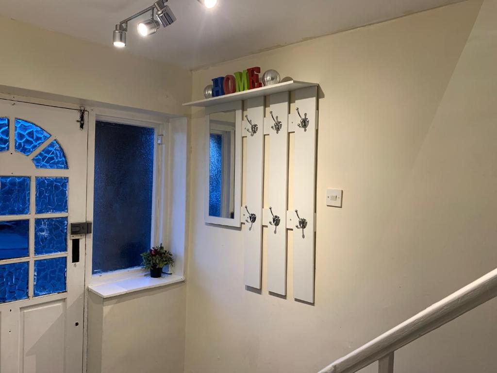 a hallway with white walls and a white door and a window at Contractor & Family Friendly House Romford in Havering atte Bower