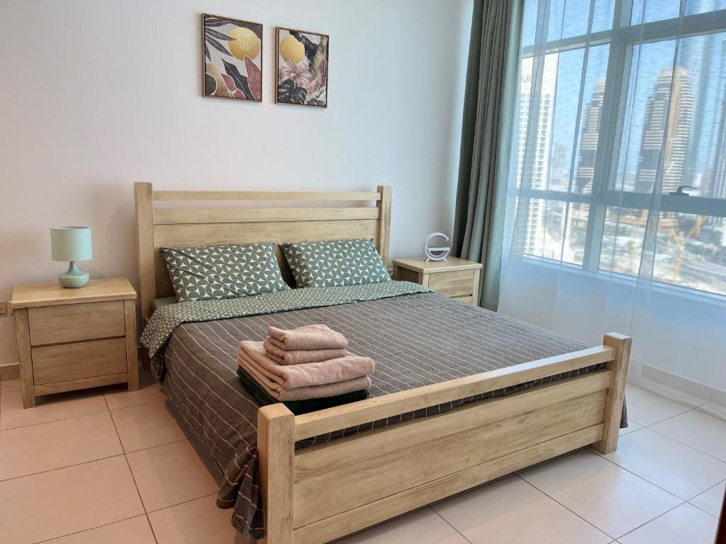 a bedroom with a bed and a large window at Amazing 1 bedroom apt in Marina in Dubai