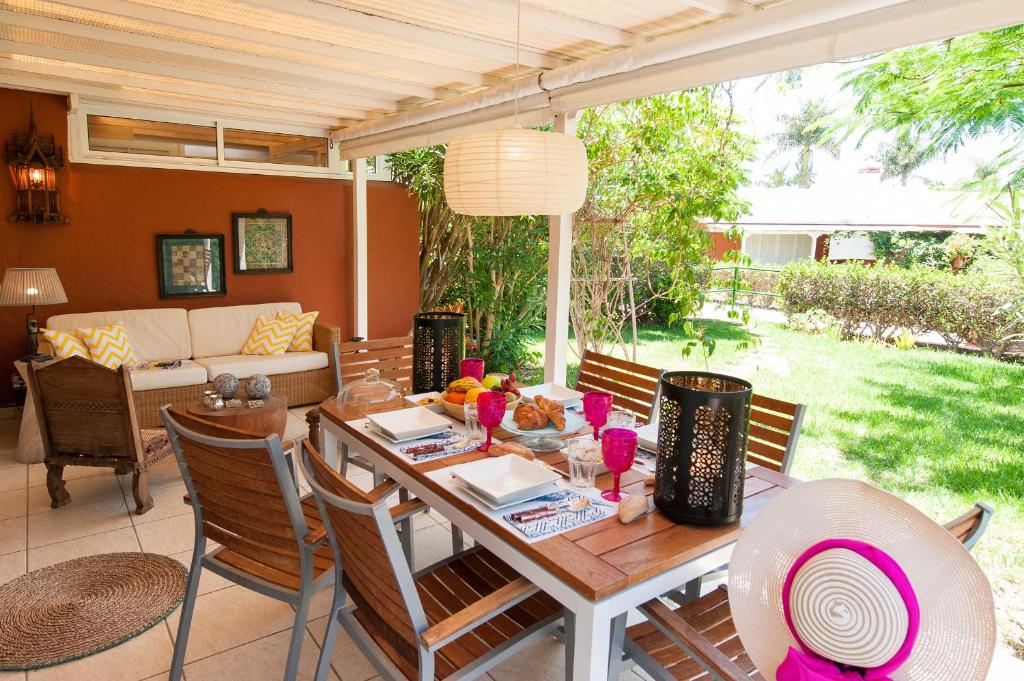 a dining room with a table and chairs at Bungalow Melocotones Maspalomas Golf in Maspalomas